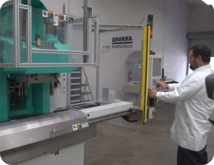 Protoshop Team Member Working With Arburg Allrounder Injection Molding Machine - Injection Molding Process Graphic